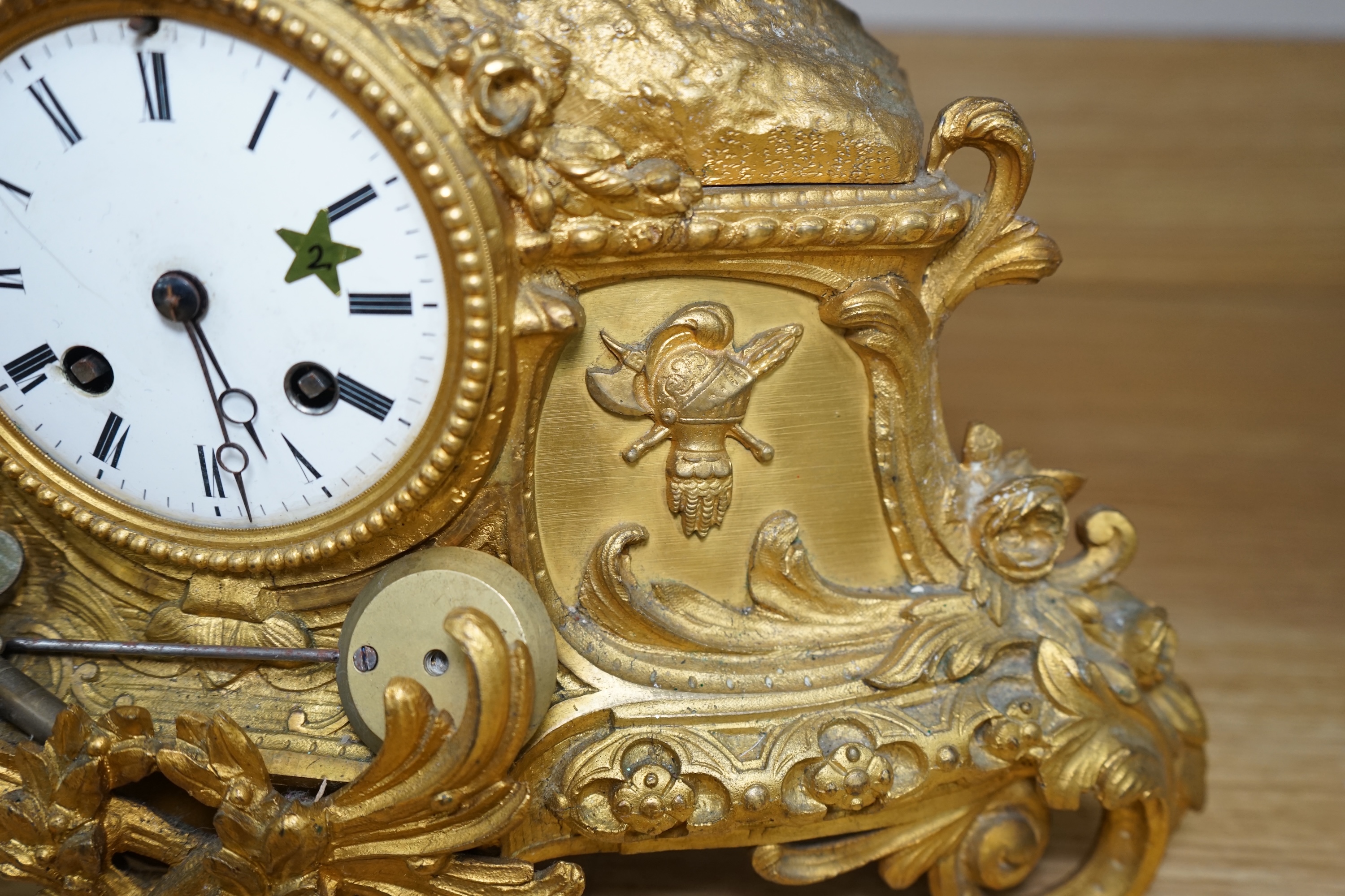 A late 19th century French ormolu mantel clock surmounted with a cavalier on horseback, key and pendulum, 38cm. Condition - fair to good